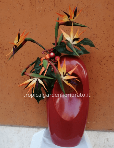 Composizione con strelizie artificiali e vaso ceramica rosso