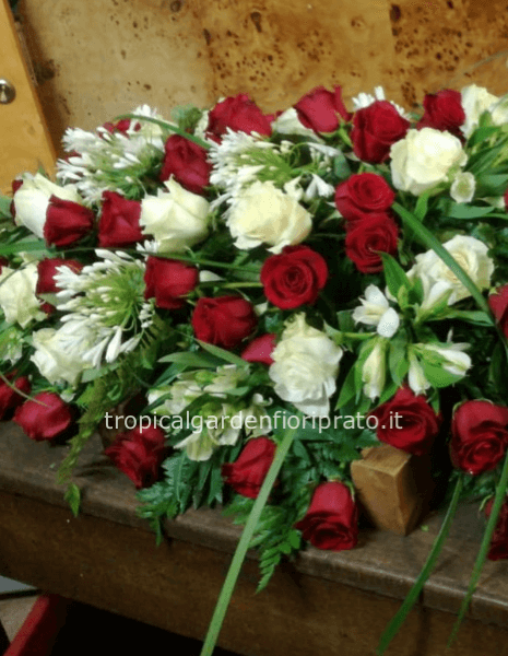 Copricassa con rose rosse, bianche e fiori bianchi di stagione