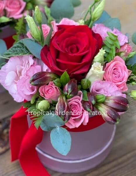 Flower box con rosa rossa centrale e fiori rosa di stagione.
